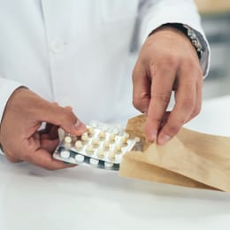 Ein Apotheker pakte einzelne Medikamente in eine Tüte ein
