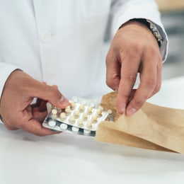 Teilmengenabgabe von Medikamenten durch Apotheken Ein Apotheker pakte einzelne Medikamente in eine Tüte ein